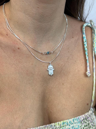 Colar duplo veneziana com olho grego e hamsa, acabamento polido e simbólico.