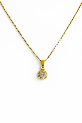 Colar ponto de luz banhado a ouro 18k da UNA Semijoias e Aço em fundo branco, com pingente redondo cravejado de zircônias em destaque.