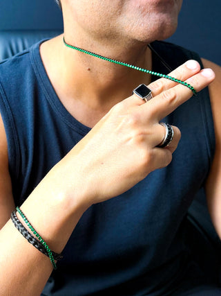 Colar masculino de aço inox black com pedras verde-esmeralda da UNA Semijoias e Aço no pescoço do modelo em lifestyle, com destaque para o brilho das zircônias.