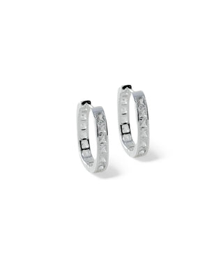 Par de argolas médias modelo click cravejadas com zircônias, banhadas a prata 925 da UNA Semijoias e Aço em fundo branco, semijoias finas de luxo.