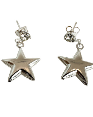 Par de brincos estrela banhados a prata 925 da UNA Semijoias e Aço em fundo branco, com pingente de estrela lisa e ponto de luz no topo.