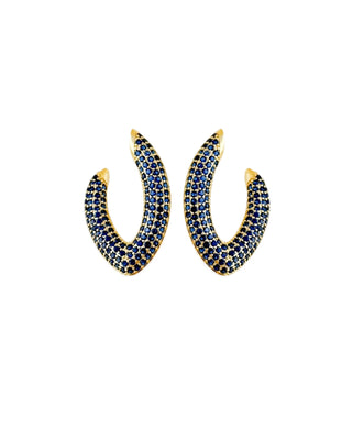 Brinco médio em formato de V cravejado com zircônias azuis, banhado a ouro 18k da UNA Semijoias e Aço em fundo branco, semijoia fina de luxo ideal para dia a dia e eventos.