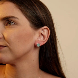 Par de brinco pequeno redondo verde banhado a prata 925 da UNA Semijoias & Aço em fundo branco, semijoia hipoalergênica, estilo minimalista.