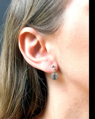 Brinco São Bento banhado a prata 925 da UNA, semijoia religiosa fina e sofisticada, ideal para dia a dia, reuniões e eventos. Proteção e estilo com 1 ano de garantia.