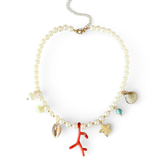 Choker de bijuteria fina com contas tipo pérola e pingentes do mar em resina vermelha e metal dourado da UNA Semijoias e Aço em fundo branco.