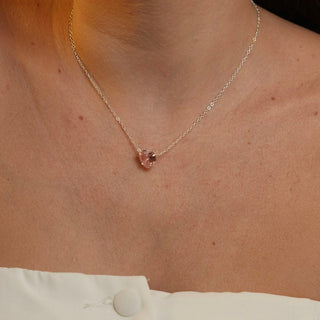 Colar com pingente de coração em pedra de vidro rosa claro banhado a prata 925 da UNA Semijoias e Aço em fundo branco, em vista frontal