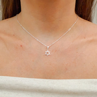 Colar Estrela de Davi vazada banhado a prata 925 da UNA Semijoias e Aço em fundo branco, com pingente delicado e corrente fina em destaque ao centro.