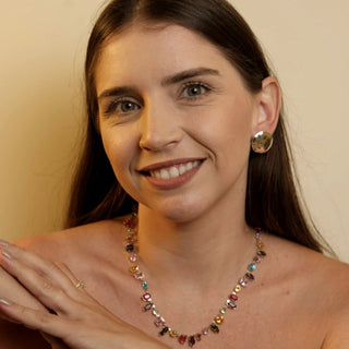 Colar mix de pedras de vidro coloridas banhado a ouro da UNA Semijoias e Aço no colo feminino em close, com destaque para as pedras.