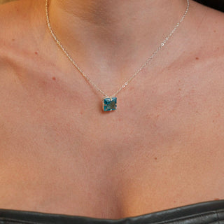 Colar quadrado com pedra de vidro verde banhado a prata 925 da UNA Semijoias e Aço em fundo branco, pingente quadrado em destaque no centro.