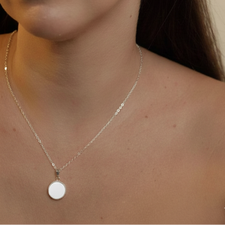 Colar redondo branco banhado a prata 925 da UNA Semijoias e Aço em fundo branco, semijoia antialérgica delicada com pingente circular.