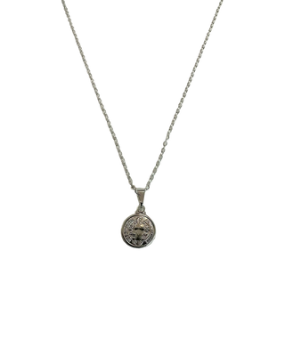 Colar São Bento banhado a prata 925 da UNA Semijoias e Aço em fundo neutro claro, com medalha religiosa redonda em destaque na corrente.