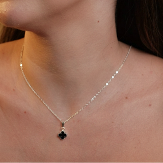 Colar trevo preto banhado a prata 925 da UNA Semijoias e Aço em fundo branco, com pingente de trevo delicado em destaque no centro.