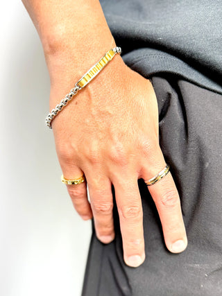 Pulseira masculina de aço inox com detalhe dourado da UNA Semijoias e Aço no pulso masculino em close, acessório moderno, antialérgico e de acabamento fino.