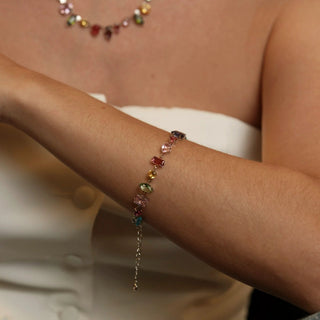 Pulseira mix de pedras de vidro coloridas banhada a ouro da UNA Semijoias e Aço no pulso feminino em close, com destaque para as pedras.