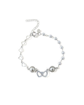 Pulseira com pérolas e pingentes de corações duplos banhada a prata 925 da UNA Semijoias e Aço em fundo branco, em vista frontal.