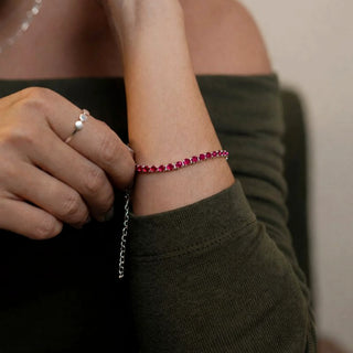 Pulseira riviera rosa banhada a prata 925 da UNA Semijoias e Aço no pulso feminino em close, com corrente ajustável e acabamento delicado em destaque.