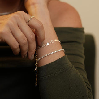 Pulseira riviera transparente banhada a prata 925 da UNA Semijoias e Aço em fundo branco, com extensor ajustável e fileira de pedras brilhantes.