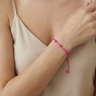 Pulseira verão nozinho da sorte rosa da UNA Semijoias e Aço em fundo branco, com cordão rosa ajustável e nós delicados distribuídos pela pulseira.
