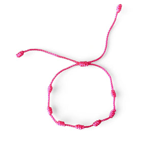 Pulseira verão nozinho da sorte rosa da UNA Semijoias e Aço em fundo branco, com cordão rosa ajustável e nós delicados distribuídos pela pulseira.