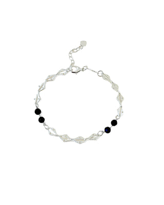 Pulseira fina com elos em losango banhada a prata com contas de zircônia preta da UNA Semijoias e Aço em fundo branco, vista frontal.